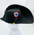 Black tricorn hat with decorative emblem on a white background