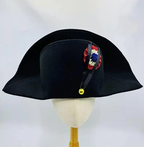 Black tricorn hat with decorative ribbon on a mannequin head against a white background