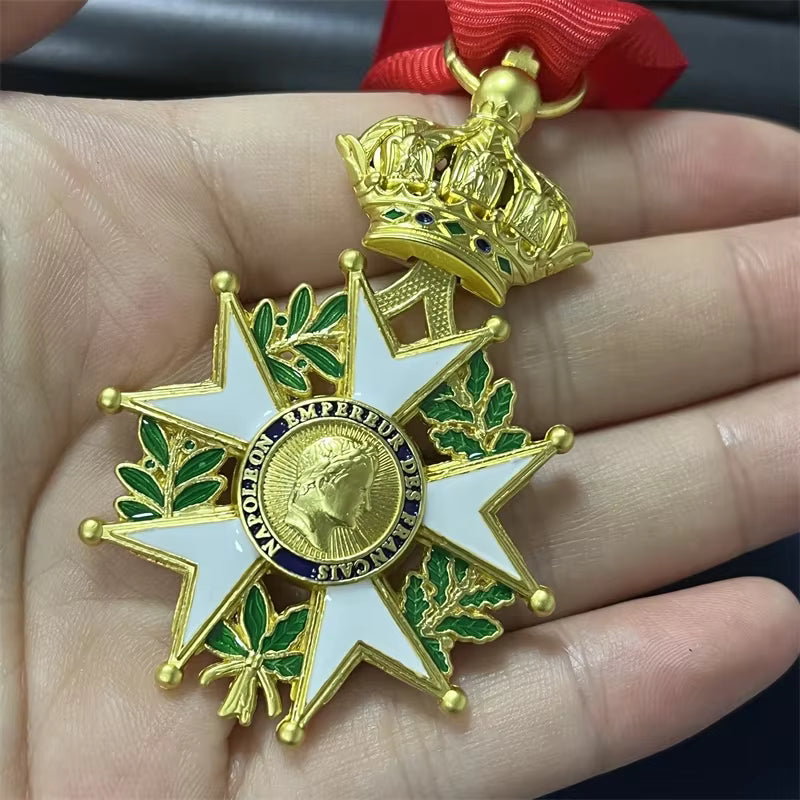 Gold and green medal with red ribbon held in a hand