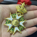 Gold and green medal with red ribbon held in a hand