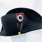 Black bicorne hat with decorative emblem on a white background