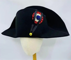 Black bicorn hat with decorative emblem on a mannequin head against a white background