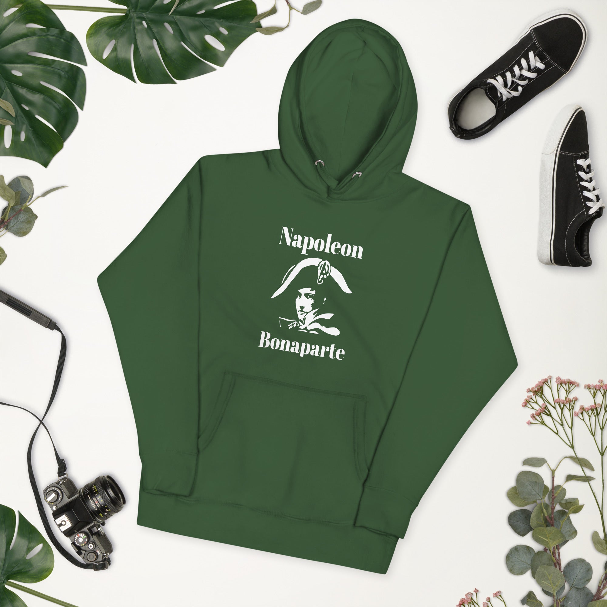 Green hoodie with 'Hustle Hard' text, surrounded by leaves and a camera on a white background as french souvenir