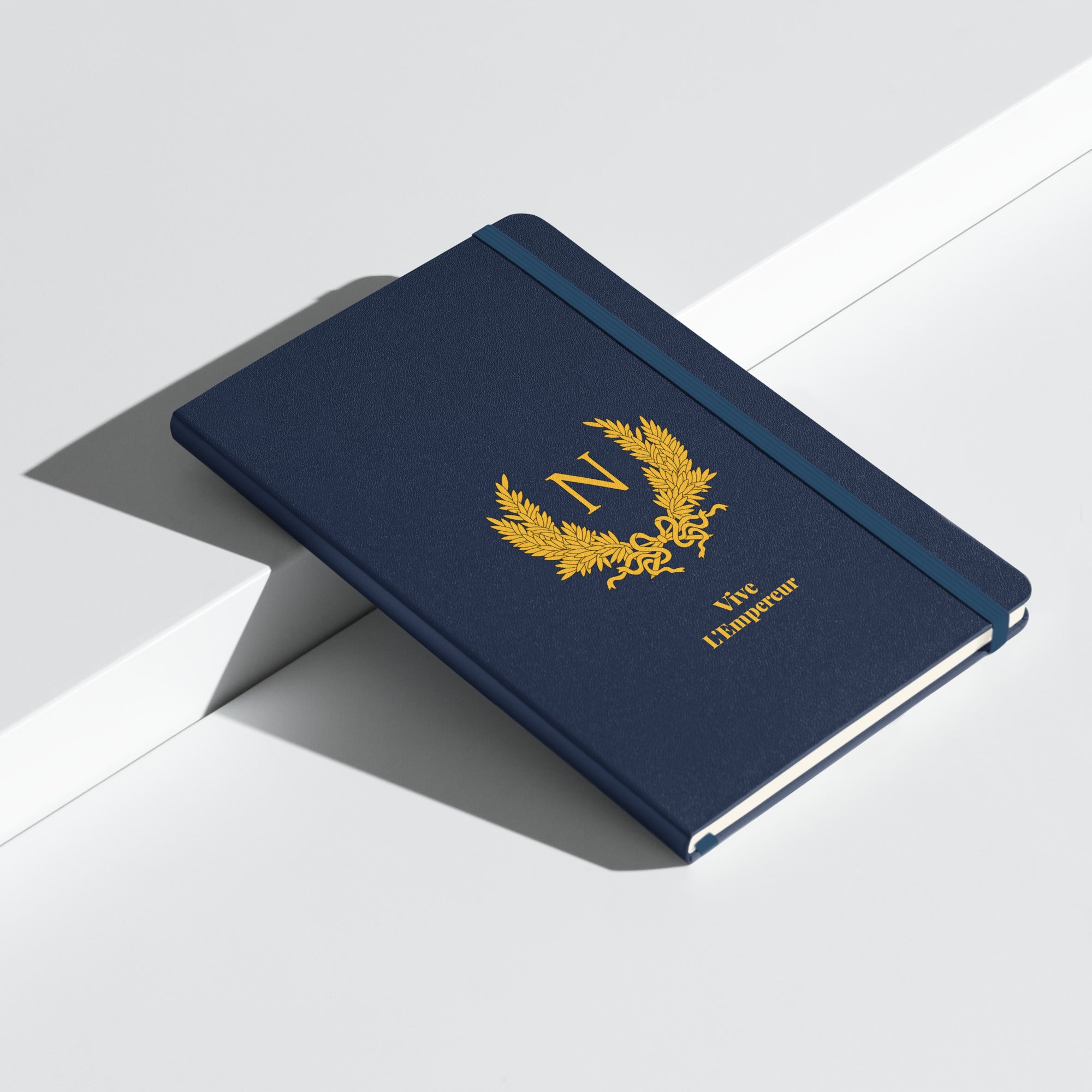 Blue notebook with gold emblem and text on a white surface
