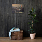 Wicker basket with folded clothes against a dark wooden wall with a painting and a potted plant.