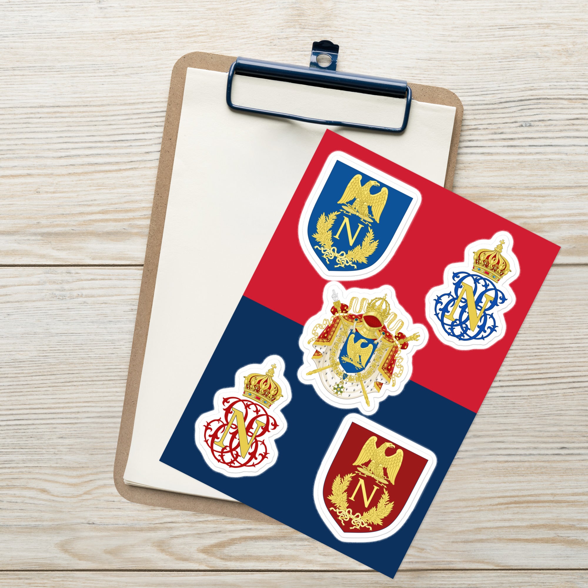 Sheet of stickers with heraldic designs on a clipboard against a wooden background