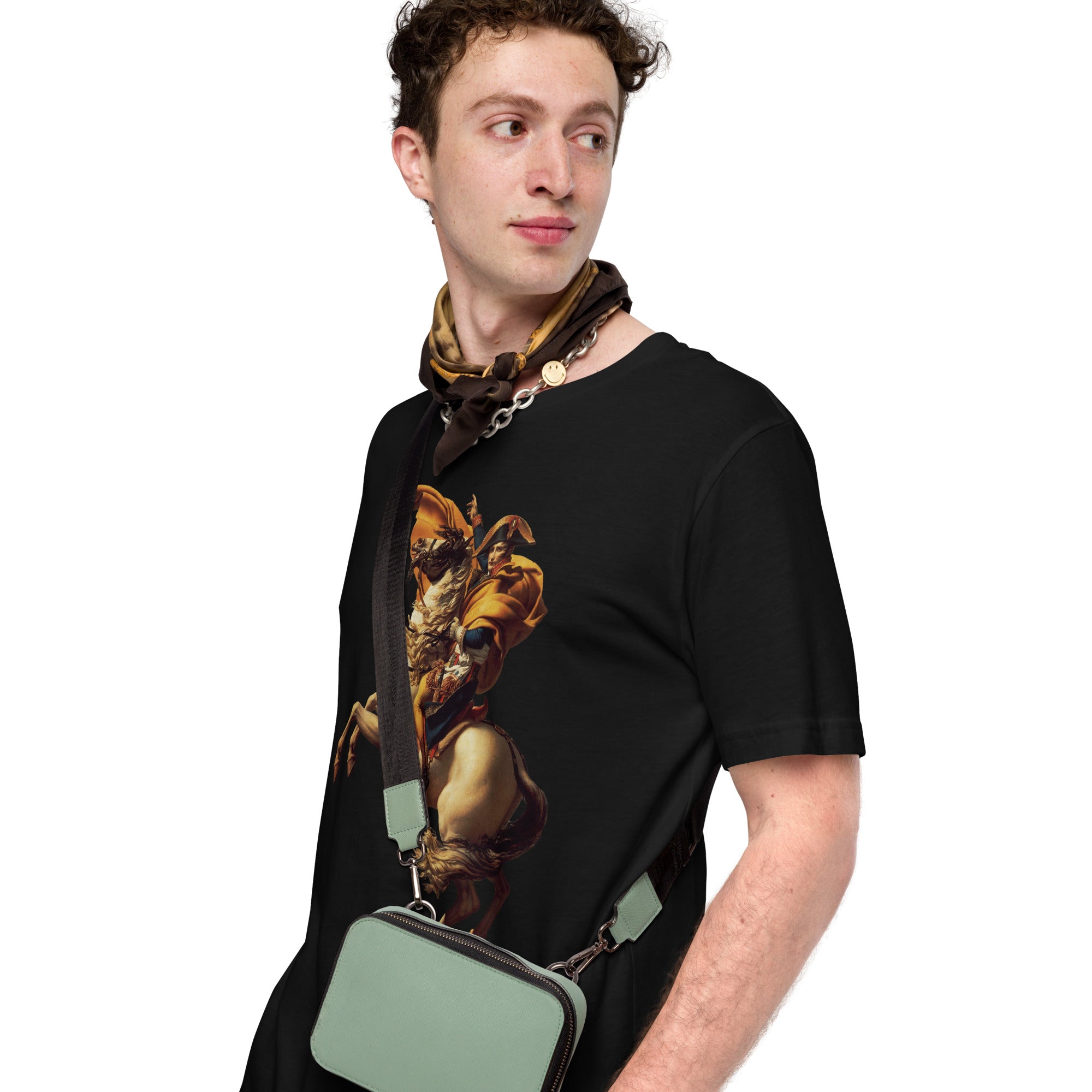 Man wearing a black t-shirt with a graphic design, holding a green bag on a white background